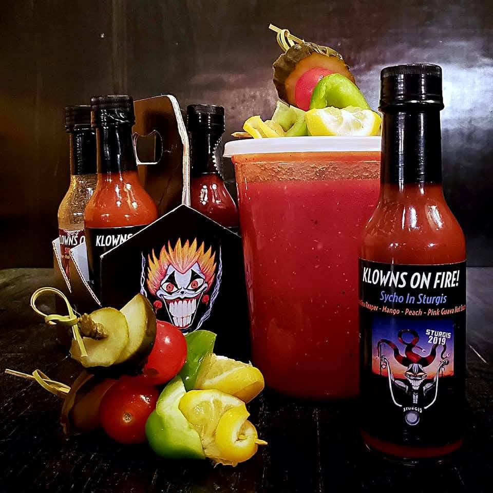 A vibrant lineup of Klowns On Fire hot sauces at the market